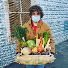 Load image into Gallery viewer, a boy holding a tray of local produce and a large pumpkin