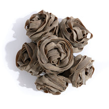 Load image into Gallery viewer, pile of brown pasta balls where each ball is made of flat pasta