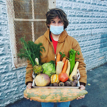Load image into Gallery viewer, a boy holding a tray of local produce and a large pumpkin
