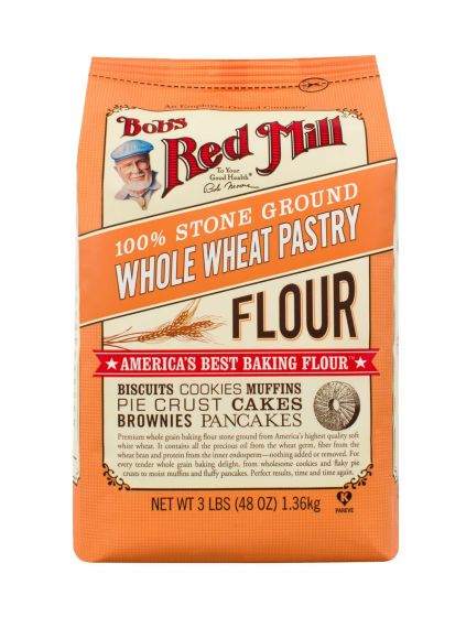 An orange sack of bob's red mill stone ground whole wheat pastry flour. Sack includes an image of a grinding mill stone