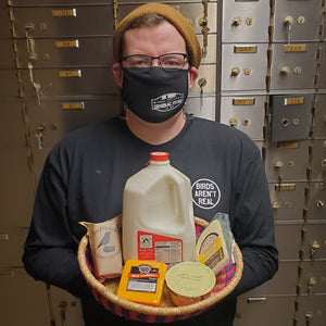 Jon Henry holding an african basket of dairy items like cheese and milk