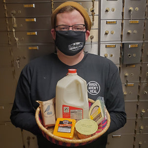 jon holding a basket of dairy items like milk cheese and ice cream and yogurt