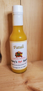 large glass bottle with yellow liquid of fatali hot sauce