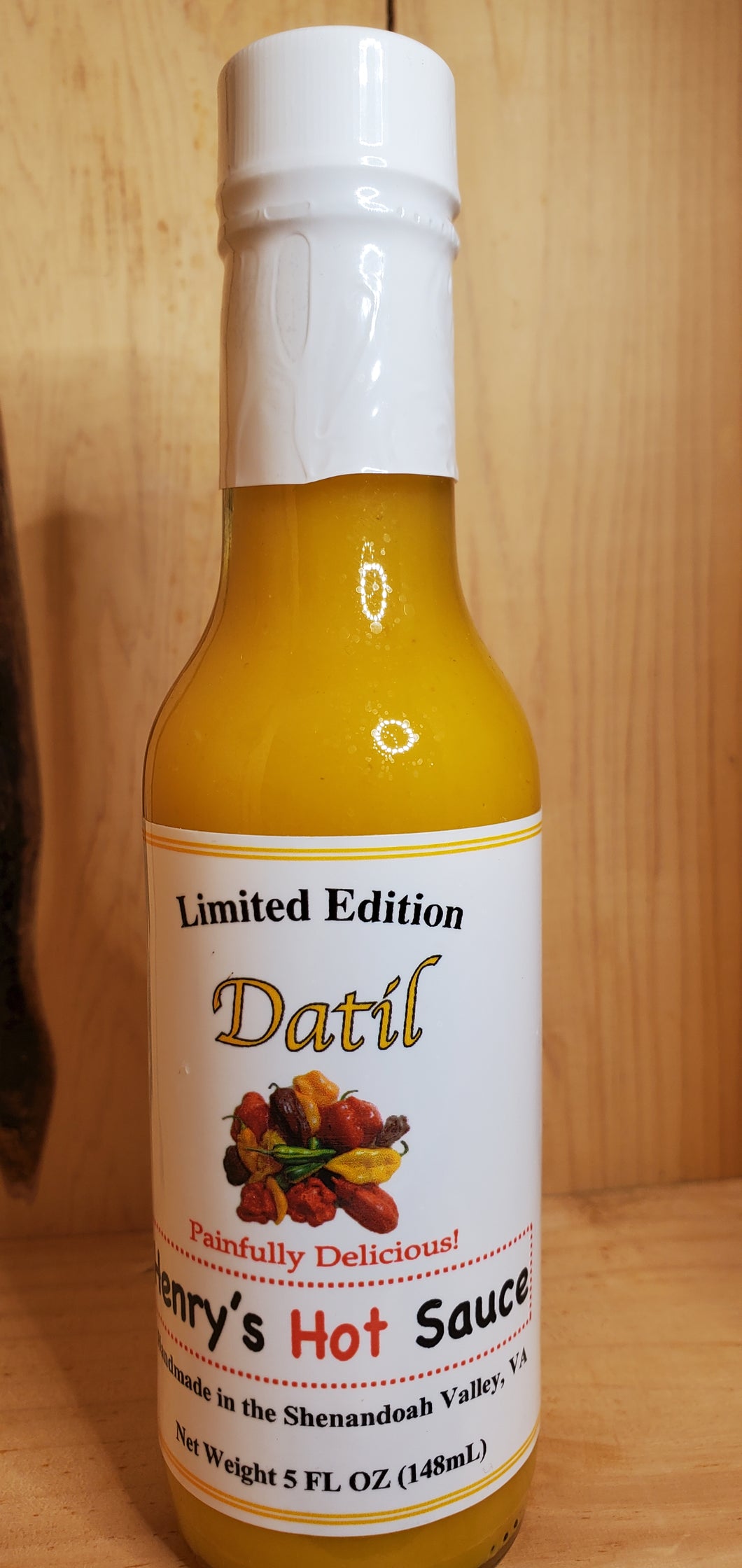 large glass bottle of yellow datil hot sauce