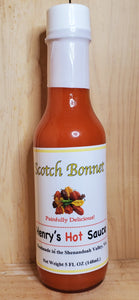 large glass bottle with red scotch bonnet hot sauce