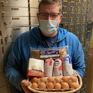 jon holding a basket of meat like eggs, burger, bacon, and sausage 