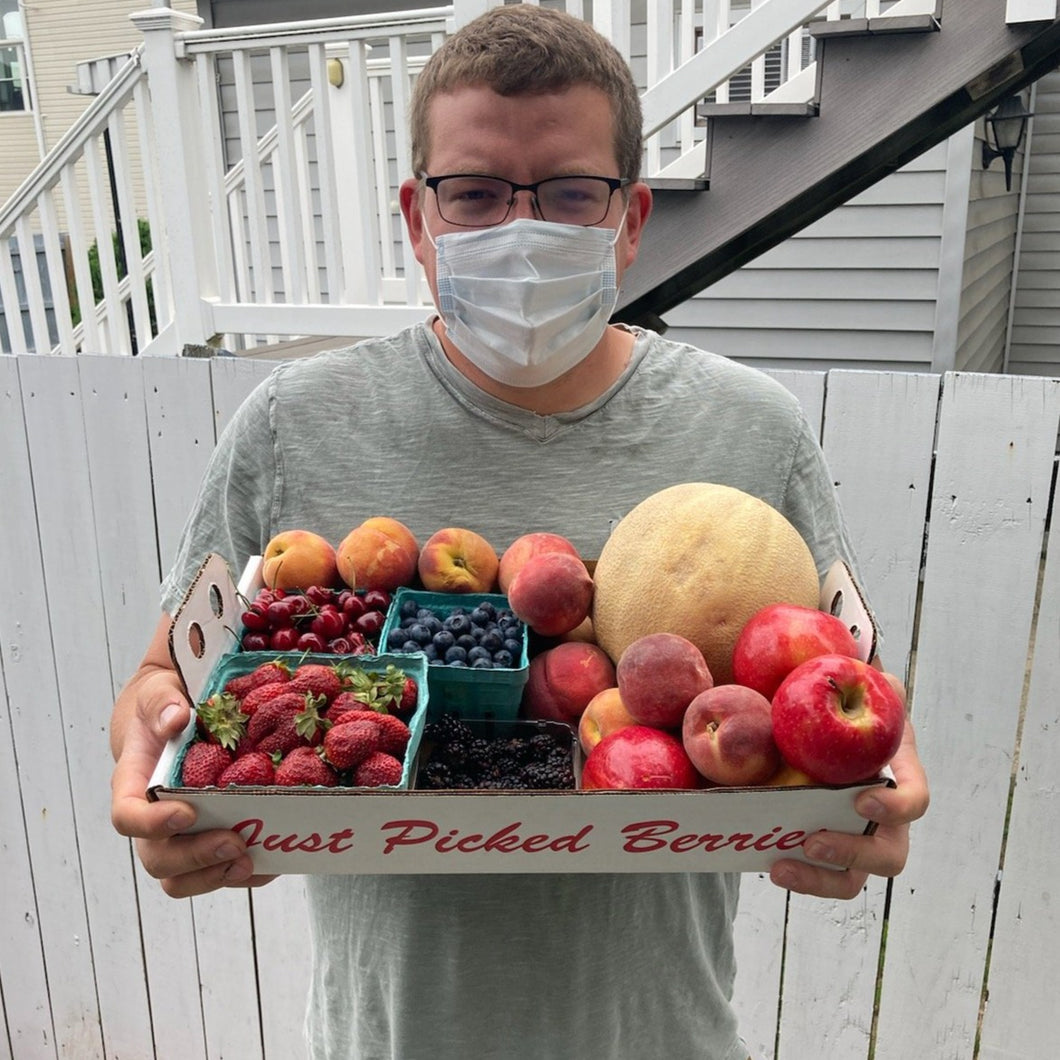 Jon holding a mix box of fruit