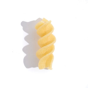 single piece of spiral pasta casting a large shadow