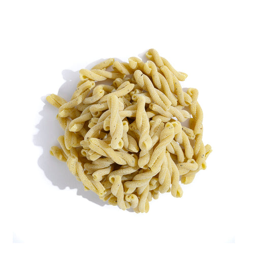 pile of yellow pasta with green specks in a helix shape