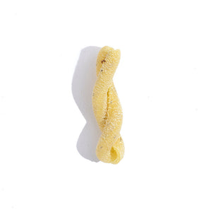 a single piece of yellow pasta with green specks in a helix shape