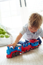 Load image into Gallery viewer, a small boy playing with a train set

