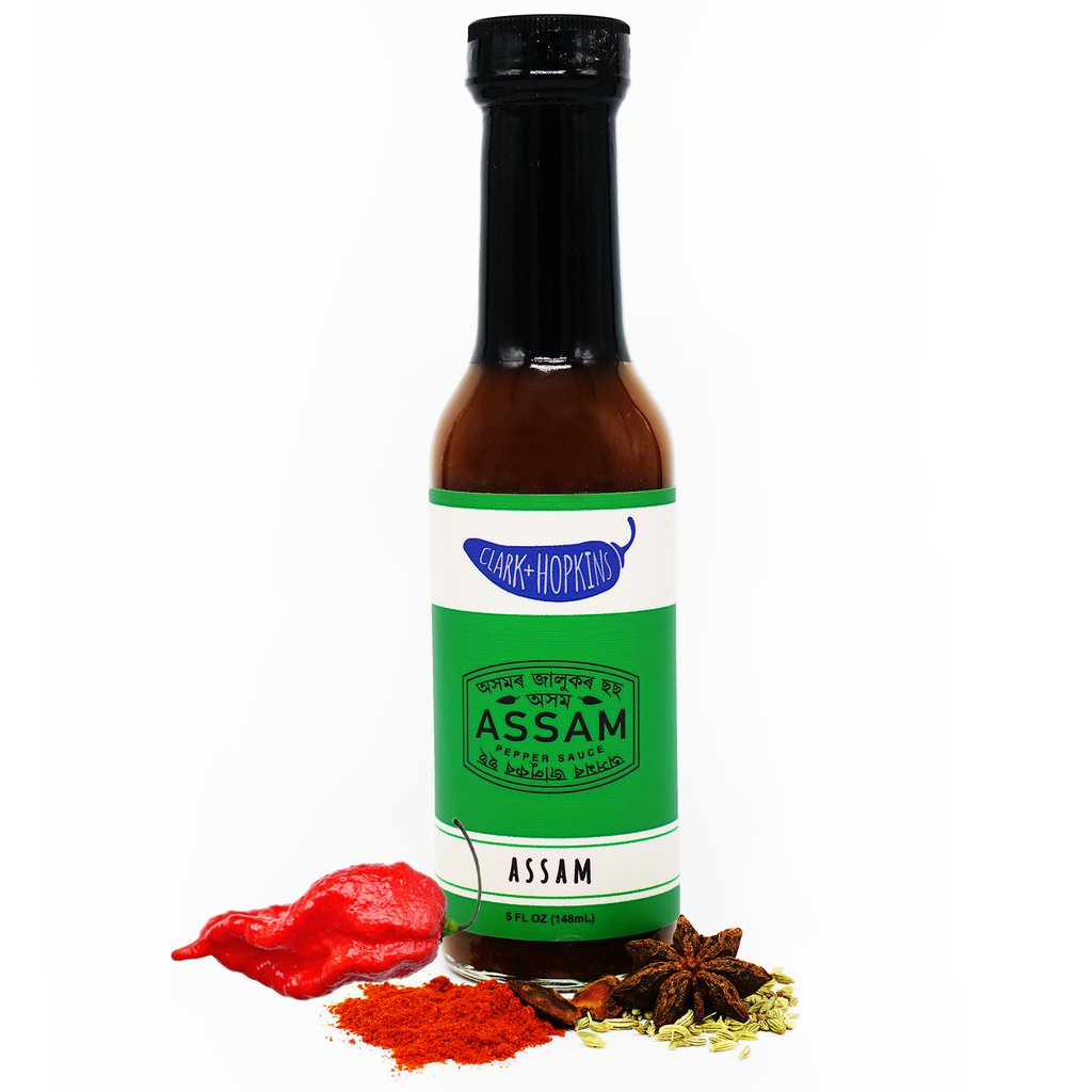 green label of assam hot sauce in glass bottle